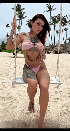 Sexy Tattooed Chick in a Bikini Swinging on a Swing'