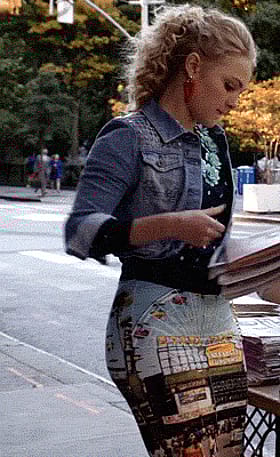 Saucy minx teasing in a snug skirt while grabbing the paper'